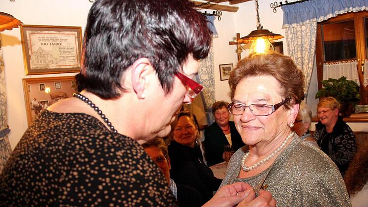 Antonie Vian steckt Marianne Weller die Ehrennadel an