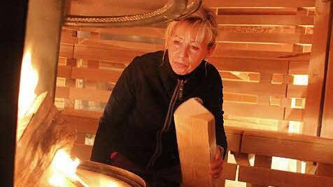 Cordula Reichardt befeuert den Kamin in der Erdhügelsauna.