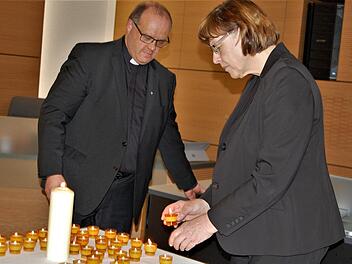 Pfarrer Gerd Greier und Pfarrerin Christel Mebert entzündeten Kerzen zur Erinnerung an die ermordeten Opfer des Nazi-Regimes. Foto: Sigismund von Dobschütz
