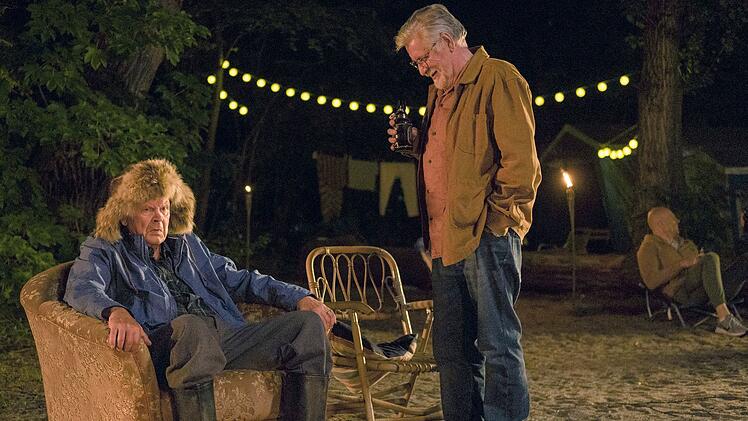 Tarmo (Kari V&auml;&auml;n&auml;nen, Mitte) steht mit seinem Wohnmobil, in dem er seit vielen Jahrzehnten lebt, auf einem Campingplatz, der wie eine moderne Hippiekommune anmutet. Der alte Griesgram (Heikki Kinnunen) kann damit wenig anfangen.