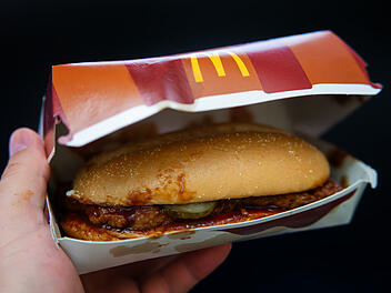 McRib McDonald&rsquo;s McDonalds Papierbox Hand Takeaway ToGo Fastfood BBQ Schweinefleisch Sandwich Abschied 37 Jahre Streichung Auslistung Kultklassiker Nostalgie Men&uuml; R&uuml;ckzug Symbolbild Gastronomie Kette Saucig Limited Edition Verpackung Unterwegs Snack Fans GERMANY - SEP 30, 2023: McDonald's McRib in a Paper Box Held in Hand