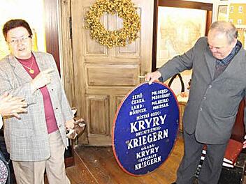Von 1918 bis 1938 zierte ein zweisprachiges Schild die Ortschaft Kryry, vormals Kriegern. Uta Bräuer von der "Podersamer Heimatstube" begeisterte die Gäste aus dem heutigen Tschechien, als sie ihnen ein Originalortsschild aus der Vergangenheit präsentierte. Mit im Bild Bürgermeister Miroslav Brda. Foto: Rainer Glissnik