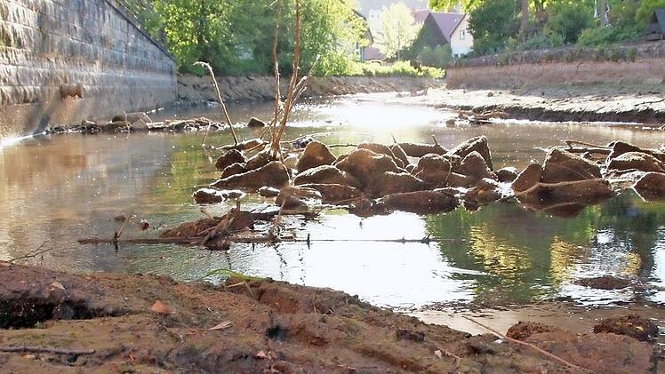 Die Steine unterhalb der Brücke Am Breitenbach sorgen für Stromschnellen. Der Ansaugstutzen der Feuerwehr (links) hängt in der Luft.  Foto: Josef Hofbauer