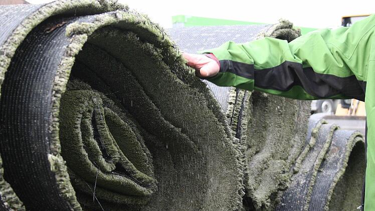 Beim Anfassen der Rasenrollen rieselt noch der Quarzsand heraus.