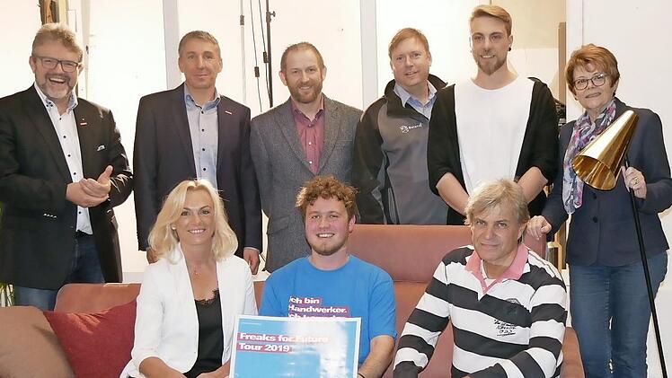 Firmenehepaar Brigitte und Arno Greiner auf der Couch mit seinem ehemaligen Azubi Johannes Heppner, der nach seiner Lehrzeit nun als festangestellter Fotograf in den "Greinerstudios" mitarbeitet. Gratulationen gab es zudem von (von links) HWK-Präsident Thomas Zimmer, HWK-Geschäftsführer Rainer Beck, dem Stellvertreter des Landrats, Rainer Mattern, Kreishandwerksmeister Jens Beland, Philipp Greiner sowie Neustadts Zweiter Bürgermeisterin Elke Protzmann. Foto: Manja von Nida