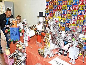 Die Klasse 2a baute Roboter. Der kleine Jan Haubenstein zeigt stolz seinem Papa Marco sein gelungenes Werk.  Fotos: Gerhard Schmidt