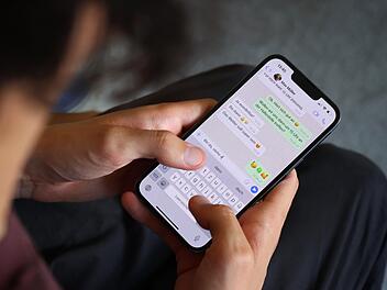 Ein junger Mann tippt eine WhatsApp Nachricht.  Karl-Josef Hildenbrand/dpa