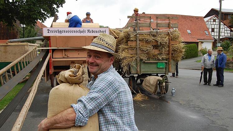 Prall gefüllte Kornsäcke werden von der Dreschmaschine gehoben.