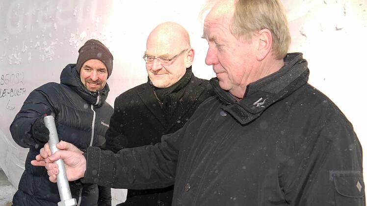 Ganz schon stabil: Nur solche starken Schrauben halten die Kräfte aus, die bei einer Windkraftanlage auf die Nabe wirken. Von links: Martin Demmeler, Dieter Scherbel und Werner Thomas. Foto: Berthold Köhler