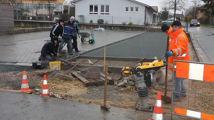 Die Helfer sorgen mit ihrem Einsatz für einen möglichst staubfreien Parkplatz an der Schule und Kindergarten Pinzberg.  Foto: Franz Galster