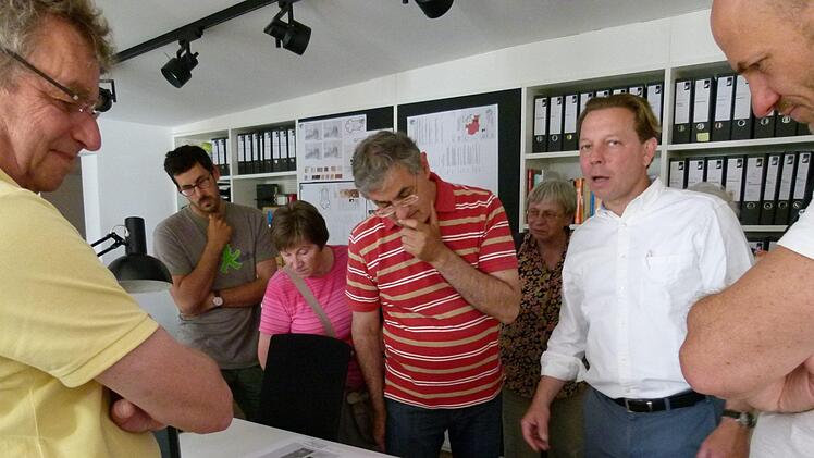 Architekt Franz Ullrich (im weißen Hemd) erläuterte vor den Bauplänen) die durchgeführten Maßnahmen.