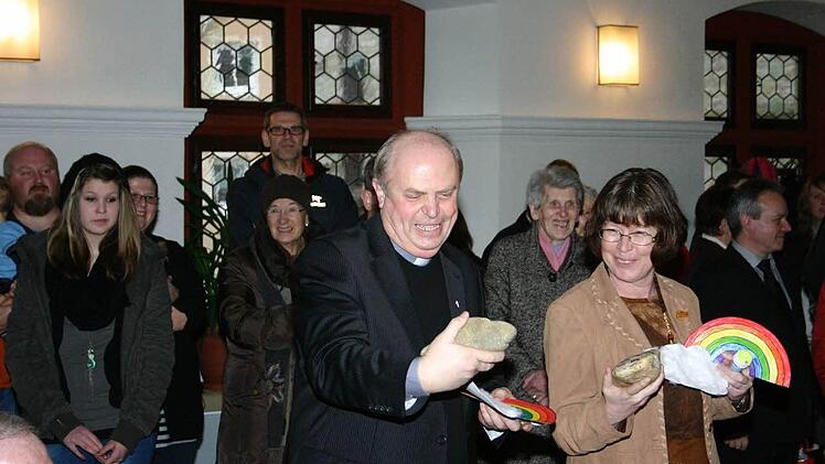 Pfarrer Adam Possmayer und Erika Gerspitzer (Gemeindereferentin) nehmen die Geschenke der Kindergartenkinder entgegen.