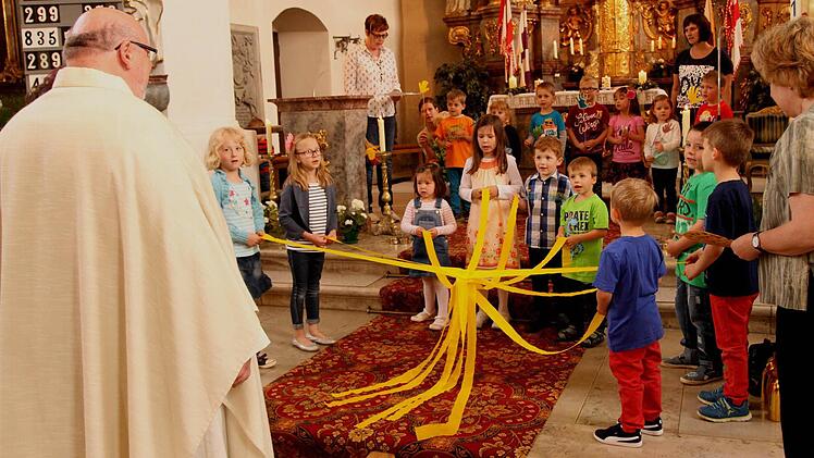 Die Buben und Mädchen aus den Kindergärten Breitbrunn und Kirchlauter bei ihren Liedern mit Bändern und Händen in der Kirche.