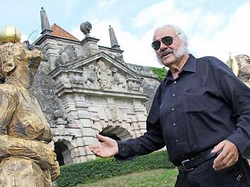 Ingo Cesaro präsentiert das Werk "Menschen auf dem Weg" von Roger Löcherbach". Während der"HolzART" fertigten zehn Bildhauer im Landkreis Kronach Kunstwerke an. Die Ergebnisse des von Cesaro initiierten Projekts stehen am Aufgang der Festung.  Foto: Andreas Schmitt