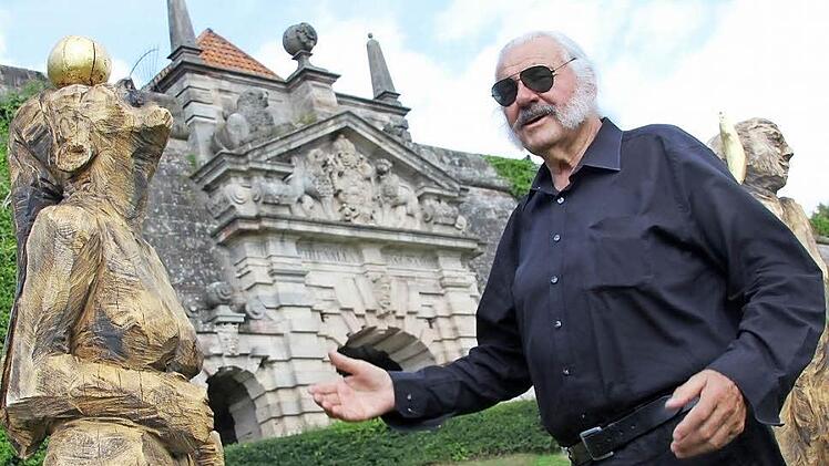 Ingo Cesaro präsentiert das Werk "Menschen auf dem Weg" von Roger Löcherbach". Während der"HolzART" fertigten zehn Bildhauer im Landkreis Kronach Kunstwerke an. Die Ergebnisse des von Cesaro initiierten Projekts stehen am Aufgang der Festung.  Foto: Andreas Schmitt