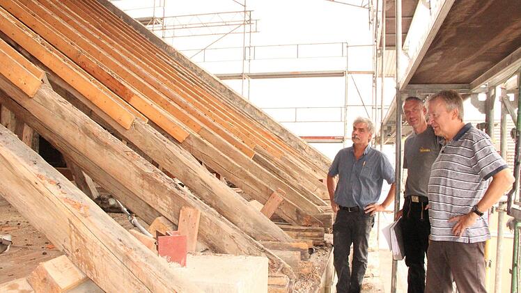 Architekt Christian Teichmann, Zimmerermeister Michael Weigand und Architekt Ralf Alsheimer beraten, wie sie den alten Dachstuhl konservieren können, ohne den Kostenrahmen zu sprengen.Heike Beudert