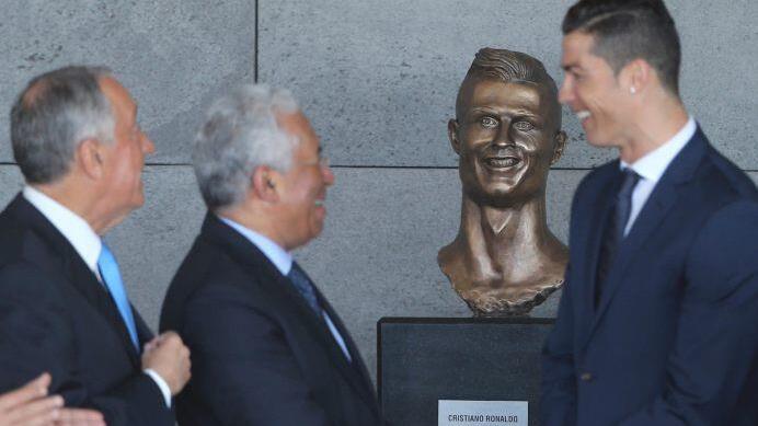 Sehen sich zum verwechseln &auml;hnlich: Cristiano Ronaldo (rechts) und seine B&uuml;ste (zweiter von rechts) im umbenannten "Cristiano Ronaldo Airport" auf Madeira. Foto: Armando Franca/AP/dpa