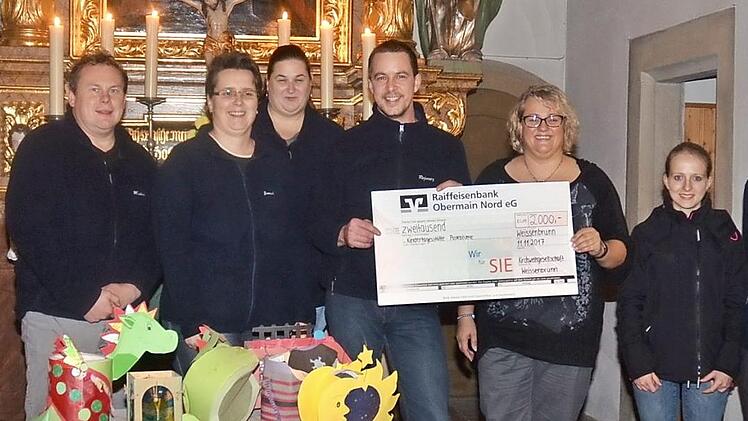 Spendenübergabe von 2000 Euro der KWG Weißenbrunn an die Kindertagesstätte "Pusteblume" Weißenbrunn. Mit im Bild die Vertreter der KWG mit Vorsitzenden Bernd Redwitz (5. v. l.) mit Kindergartenleiterin Angelika Zapfe (4. v. r.) und Pfarrer Christoph Teille (l.) Foto: K.- H. Hofmann