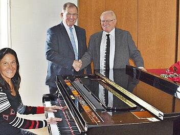 Ariadne Weigert, Dozentin für Klavier, probierte das Instrument aus Aschach aus, das Erwin Dotzel in der Berufsfachschule für Musik Bad Königshofen an Ernst Oestreicher übergab. Foto: Hanns Friedrich