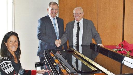 Ariadne Weigert, Dozentin für Klavier, probierte das Instrument aus Aschach aus, das Erwin Dotzel in der Berufsfachschule für Musik Bad Königshofen an Ernst Oestreicher übergab. Foto: Hanns Friedrich