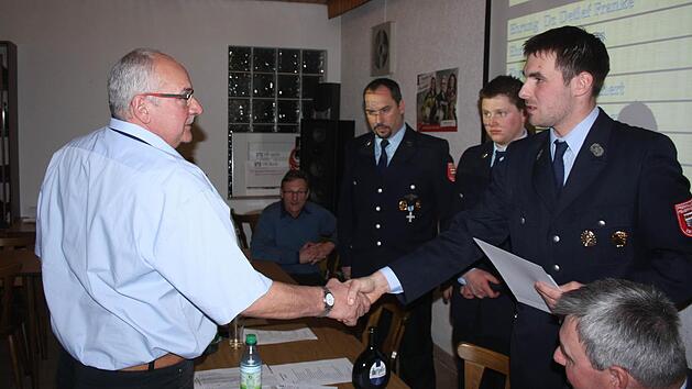 Der 1. Vorsitzende Hendrik Kenner gratuliert Alfred Hereth zum 40-jährigen Vereinsjubiläum. Im Hintergrund: Bürgermeister Wilhelm Friedrich, 2. Kommandant Torsten Hereth, 1. Kommandant Matthias Hauke, rechts Kreisbrandmeister Wolfgang Kenner.  Foto: Joachim Weichert