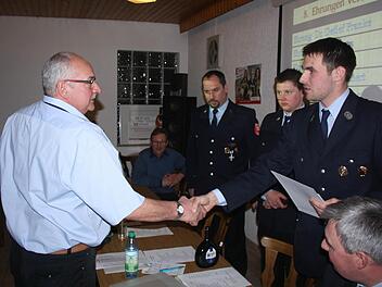 Der 1. Vorsitzende Hendrik Kenner gratuliert Alfred Hereth zum 40-j&auml;hrigen Vereinsjubil&auml;um. Im Hintergrund: B&uuml;rgermeister Wilhelm Friedrich, 2. Kommandant Torsten Hereth, 1. Kommandant Matthias Hauke, rechts Kreisbrandmeister Wolfgang Kenner.  Foto: Joachim Weichert