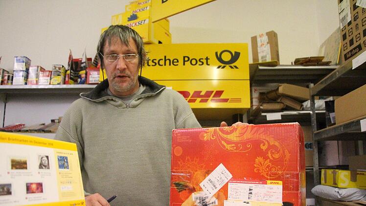 Obwohl beim Brand am Dienstagnachmittag sein Haus  unbewohnbar wurde,  bleibt Jürgen Prechtel wacker hinter der Posttheke  seines Lottogeschäfts in Uehlfeld stehen. Foto: Christian Bauriedel