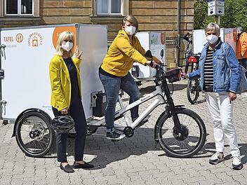 Carolina Trautner mit Ramona Lell und Luise Smolik von der Tafel Ham-melburg zeigen das neue elektrische Lastenrad. Foto: Jörg Weber