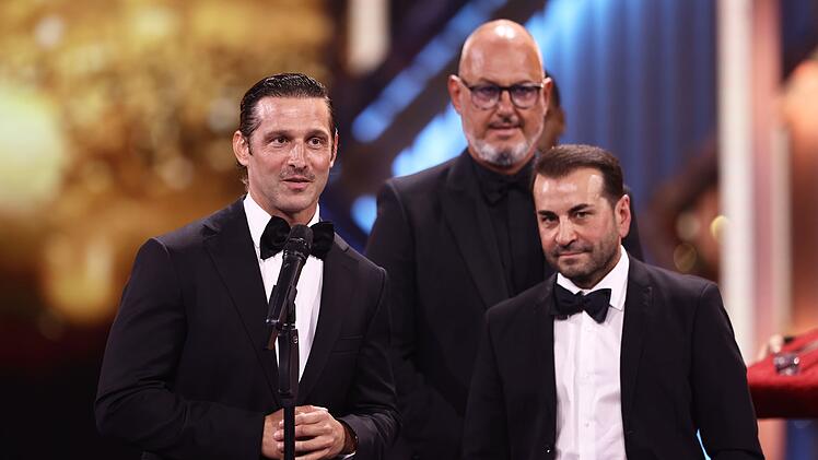 2026 gewann Ali G&uuml;ng&ouml;rm&uuml;ş zusammen mit Frank Rosin (Mitte) und Alexander Kumptner (links) den Deutschen Fernsehpreis f&uuml;r ihre Doku-Soap "Roadtrip Australien - Drei Spitzenk&ouml;che auf vier R&auml;dern".