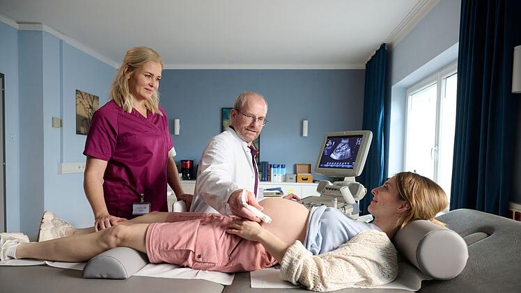 Hebamme Lena Lorenz (Judith Hoersch, links) und Dr. Keller (Thomas Limpinsel) untersuchen Vivien Ofrazek (Paula Kroh) nach ihrem Schwächeanfall.
