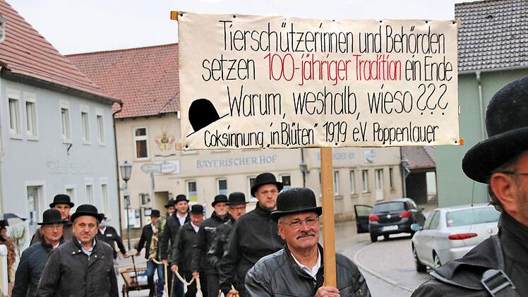 Ohne ein Schwein zogen die Mitglieder der Cocks-Innung am Dienstagmorgen  durch Poppenlauer. Der leere Schweinekäfig war mit einer schwarzen Plane  bedeckt und erinnerte entfernt an einen Sarg. Foto: Dieter Britz