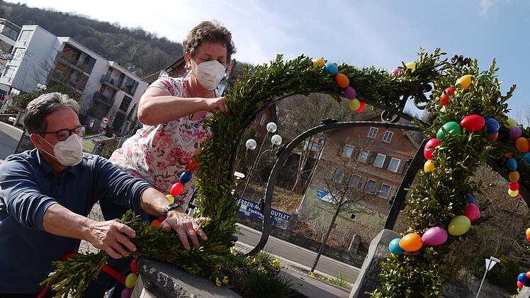 Gabriele Friedrich und ihr Mann Wolfgang schmücken den Brunnen vor dem Alten Rathaus in Bad Brückenau mit bunten Ostereiern. Fotos: Rebecca Vogt