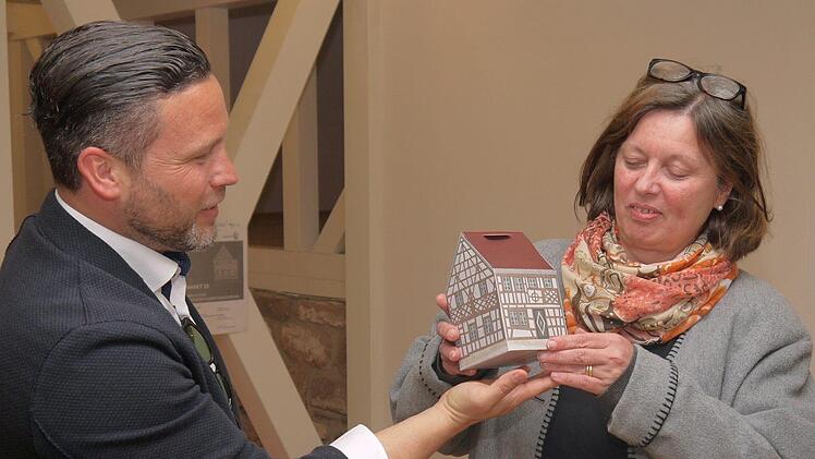 Ein Flyer, der zum Fachwerkhaus zusammengesteckt werden kann, informiert über das neue Baukompetenzzentrum. Martin Finzel und Christine Bardin probieren die Sache gleich mal aus.Berthold Köhler