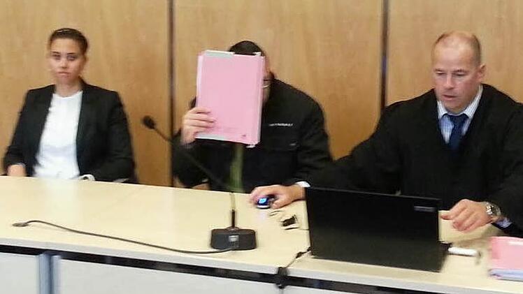 Schutz vor den Kameras: Der Angeklagte inmitten seines Verteidigers Thomas Drehsen und einer Rechtsreferendarin. Foto: Christian Pack