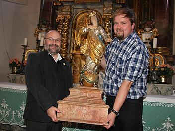 Der neue Stadtsteinacher Pfarrer Wolfgang Eßel und Mesner Andreas Dremer hieven die schwere Muttergottes vom Hochaltar, auf dem sie während der Marienfeiertage thront. Fotos: Sonja Adam