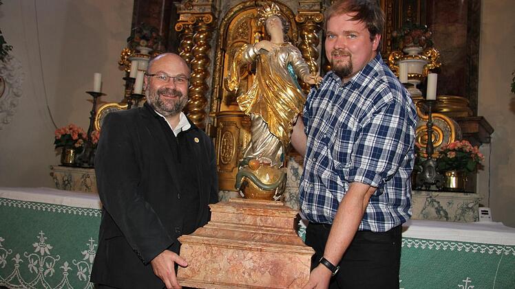 Der neue Stadtsteinacher Pfarrer Wolfgang Eßel und Mesner Andreas Dremer hieven die schwere Muttergottes vom Hochaltar, auf dem sie während der Marienfeiertage thront. Fotos: Sonja Adam