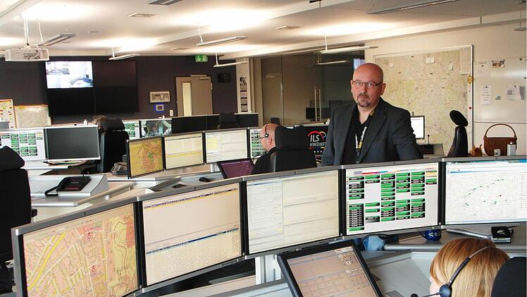 Thomas Schlereth (stehend), Leiter der ILS Schweinfurt, blickt zusammen mit seinen Mitarbeitern in der Einsatzzentrale zufrieden auf das erste Jahr zurück. Insgesamt wurden in der Region 78 123 Einsätze koordiniert, davon 21 697 im Landkreis Bad Kissingen. Foto: Michael Will