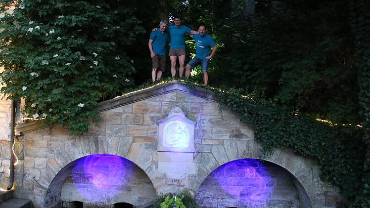 Stefan Popp, Harald Jörig und Oliver Hofmann (v. l.) mit dem probeweise illuminierten Brunnen.Matthias Einwag