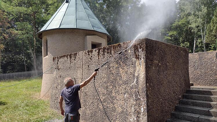Harald Dziadek beim Reinigen der Au&szlig;enmauer der Gedenkst&auml;tte mit dem Hochdruckreiniger. Foto: Thomas Helfrich