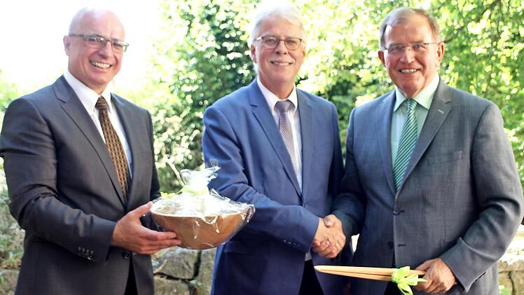 Schulleiter Oliver Dünisch (links) und Verbandsvorsitzender Bezirkstagspräsident Erwin Dotzel (rechts) bei der Verabschiedung von Geschäftsleiter Rainer Klingert Foto: Günther Geiling