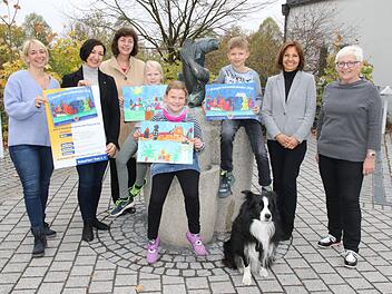 Das "Veste-Bild" von Felix Meyer ziert in diesem Jahr den Adventskalender des Lions Club Coburg Veste. V. l.: Sonja Erdel,  Ingrid Nassios, Präsidentin Lions-Club Coburg Veste,Gabriele Gruschwitz, Marie Schneider, Marlene Schneider, Felix Meyer, Schulleiterin Karina Kräußlein-Leib und Konrektorin Angelika Geiß-Dekrell mit Schulhund "Ricky". Desombre