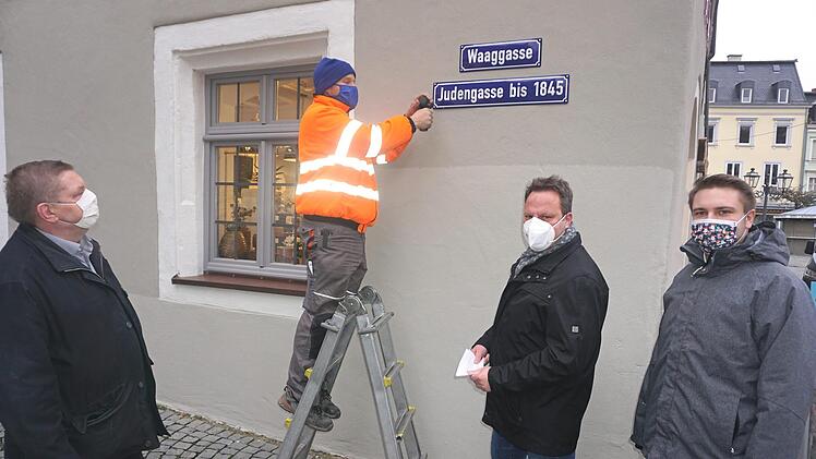Heiko Rüger vom städtischen Bauhof bringt das neue Schild an. Rechts davor Oberbürgermeister Ingo Lehmann, daneben Pressesprecher Jonas Gleich. Links im Bild Hermann Müller vom Kulturamt der Stadt Kulmbach  Foto: Wolfgang Schoberth