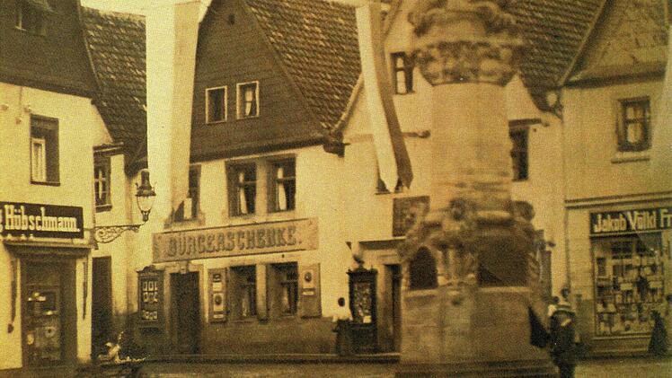 Wie sich die Zeiten ändern: Wo  der Bäcker und Brauer Andreas Ludwig von 1880 bis 1908  in seiner ,Bürgerschenke'    seine Bier verkauft, hat heute der Telekom-Shop (Langgasse 31)  sein Domizil. Auf dem Holzmarkt steht noch die Siegfriedsäule, heute der Zinsfelderbrunnen.  Foto: Stadtarchiv