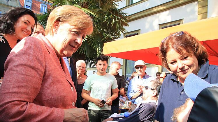 Trotz engen Zeitplans sprach die Kanzlerin kurz mit zwei Schwerbehinderten aus einer Bad Kissinger Wohngemeinschaft. Beide hatten den Wunsch, einmal Frau Merkel live zu sehen. Die Kanzlerin, eingeladen von Staatssekretärin Dorothee Bär (links), erfüllte ihn. Foto: Heike Beudert