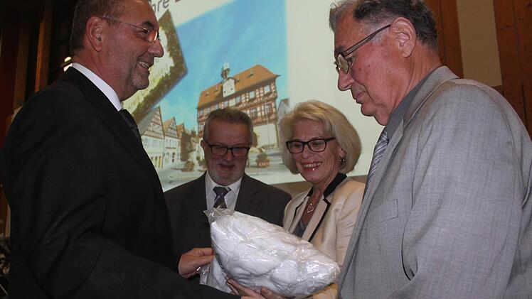 Bürgermeister Jürgen Kohmann (links) überreicht Bademäntel an (von rechts) Altbürgermeister Baptist Faulstich, die Gattin des Altlandrats, Renate Leutner, und Altbürgermeister Georg Müller. Foto: Matthias Einwag