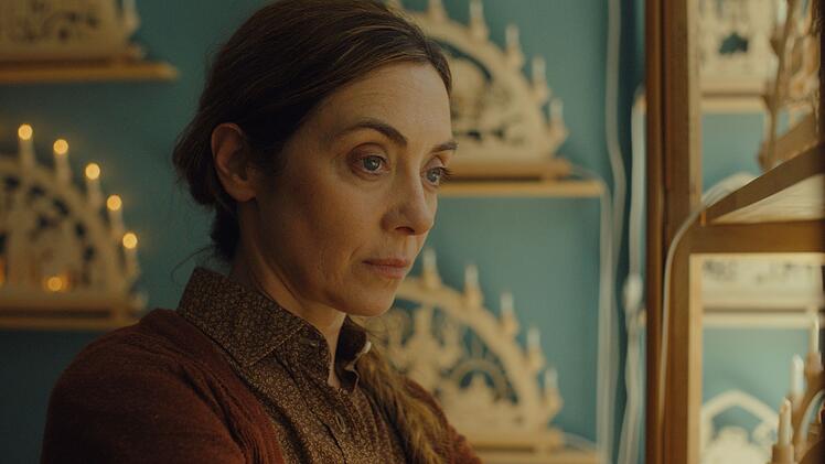 Kerstin Kampmann (Julia Richter) fertigt in einer Werkstatt mit Laden traditionelles Kunsthandwerk aus Holz, darunter die ber&uuml;hmten Erzgebirgischen Schwibb&ouml;gen (im Hintergrund zu sehen).