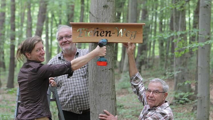 Birgit Badde (von links), Joachim Manke  und Kurt Müller bringen gemeinsam die Holz-Schilder an. Foto: Thomas Dill
