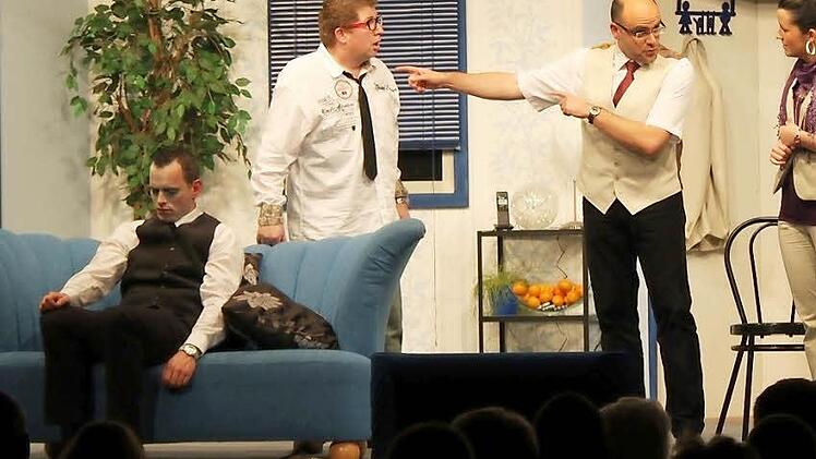 Die Leiche Albert (Manuel Ditzel) sitzt auf der Couch, während Willi (Harald Stelzner), Friedhelm (Michael Hergenröther) und Doris (Nicola Kretz) diskutieren.   Fotos: Steffen Vetter