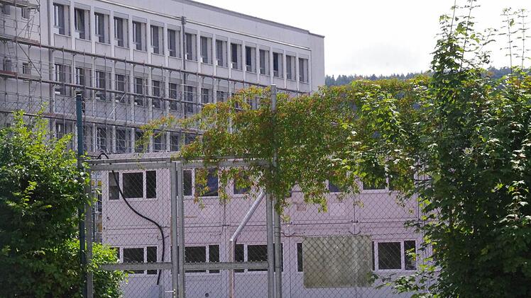 Die Schulleitung des Kaspar-Zeuß-Gymnasiums Kronach hat ein Einsehen mit den Schülern der Q 12. Sie dürfen sich nun weitgehend im Schulgebäude statt in den ungeliebten Containern (vorne) auf ihr Abitur vorbereiten. Foto: Marco Meißner