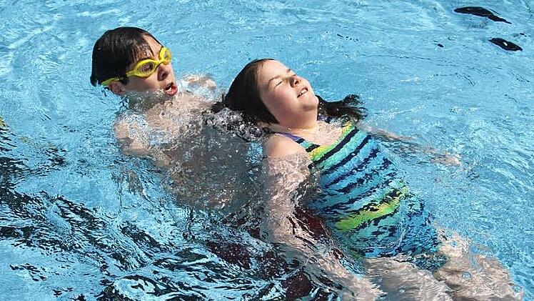 René Wiefek ist selbst mit der Rettungsleine gesichert und schleppt das "Badeopfer" Mona ab. Fotos: Sonja Adam